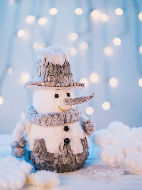 Pequeño muñeco de nieve de juguete en mesa blanca