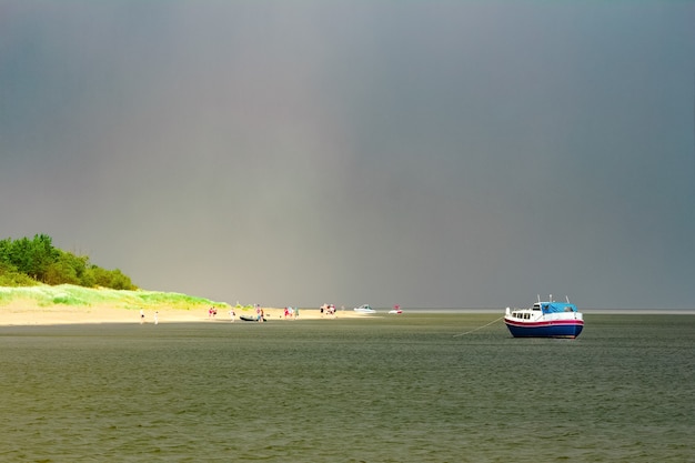 Pequeno navio de passageiros azul atracado na baía do Mar Báltico