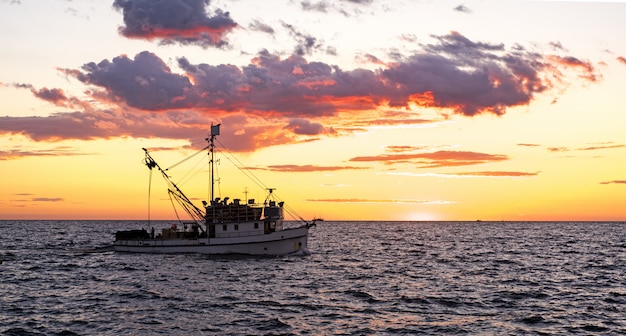 Pequeno navio no mar. dia de verão por do sol.