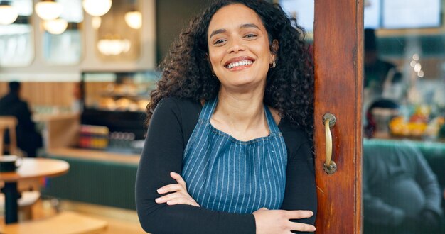 Pequeno negócio de café e braços cruzados com sorriso garçonete e startup para entrada de café e restaurante Retrato de mulher e gerente de varejo orgulhosa e confiante na loja feliz e aberta