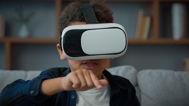 Pequeño niño afroamericano con gafas VR jugar video en línea juego 3d realidad virtual