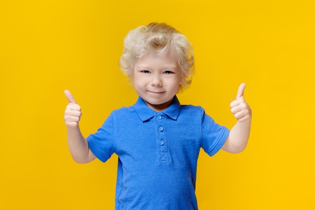 pequeño niño caucásico con cabello rubio sostiene a un niño grande con las manos hacia arriba mostrando un gesto de sonrisas de súper clase