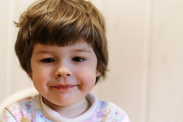 Pequeño niño caucásico sonriendo y divirtiéndose fondo blanco