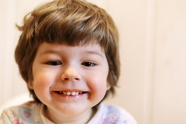 Pequeño niño caucásico sonriendo y divirtiéndose fondo blanco