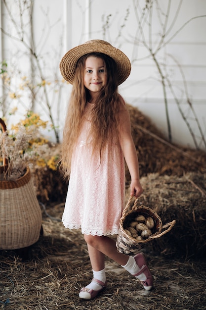 Pequeño niño encantador en vestido color de rosa y sombrero.