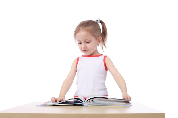 Foto pequeño niño lindo que lee un libro