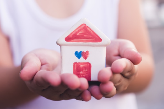 Foto pequeño niño manos sosteniendo casa