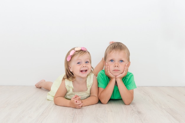 Pequeño niño y niña tirado en el piso.