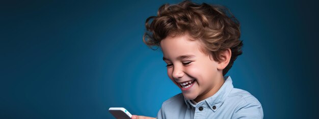 Foto pequeño niño sonriente con un teléfono celular en un fondo de color