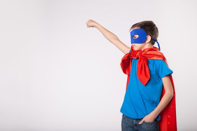 El pequeño niño superman levantó la mano