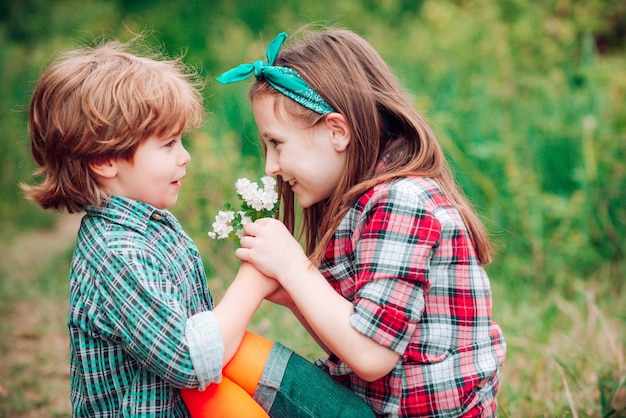 Pequeno ouple apaixonado soprando flores na cara um do outro