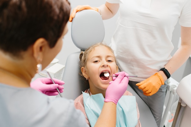 Pequeño paciente en el dentista tiene una clínica de estomatología para chequeo de dientes