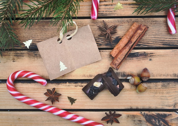 pequeño papel marrón sobre fondo de madera rústica con especias bastones de caramelo y chocolate