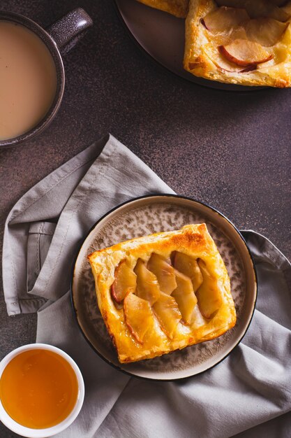 Pequeño pastel de hojaldre al revés con manzana en la parte superior de un plato y vista vertical