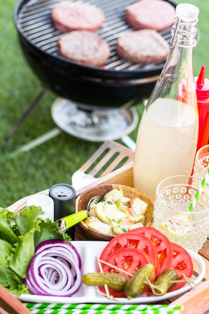 Pequeño picnic de verano con limonada y hamburguesas en el parque.