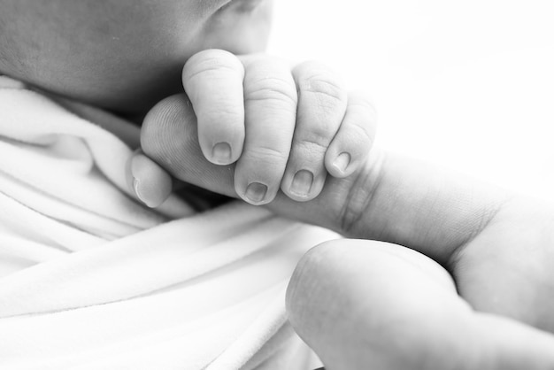 El pequeño pie de un bebé recién nacido Los pies suaves de un recién nacido en una manta de lana Un primer plano de los dedos de los pies, los talones y los pies de un recién nacido Fotografía macro en blanco y negro