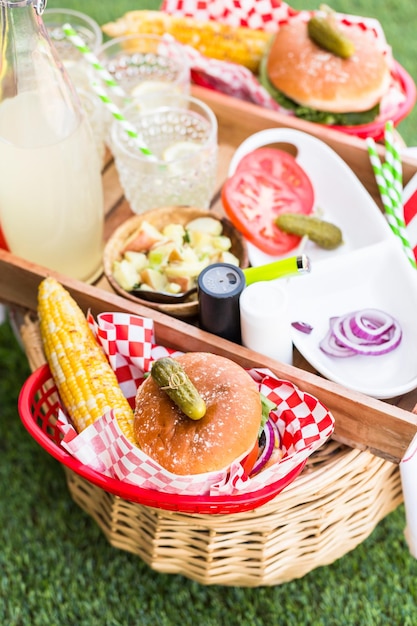 Pequeno piquenique de verão com limonada e hambúrgueres no parque.