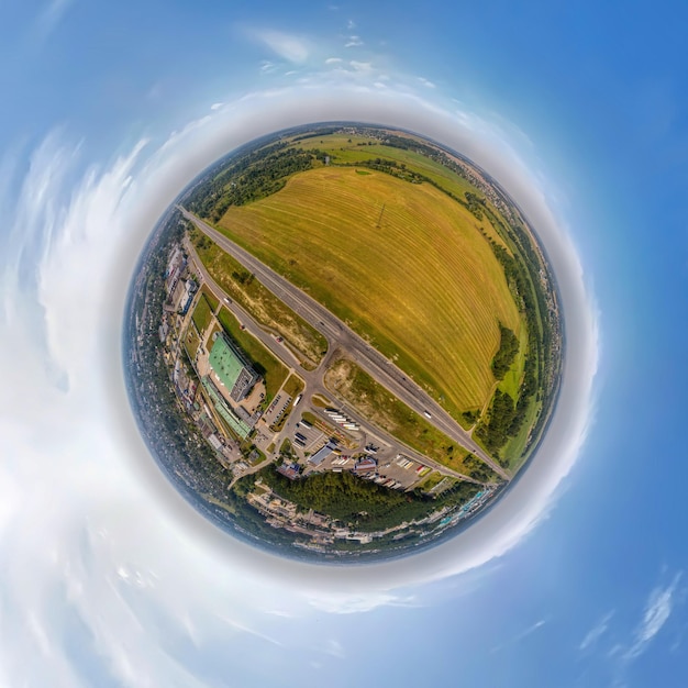 Pequeño planeta con una carretera entre un campo y una zona industrial