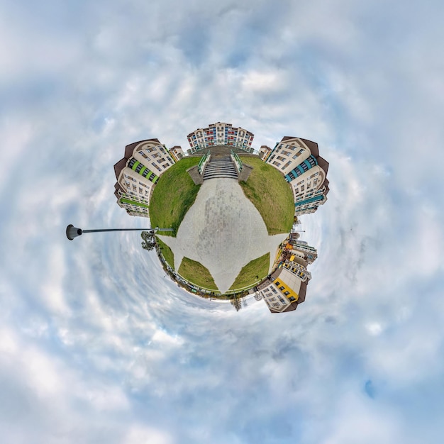 Pequeno planeta no céu com nuvens no moderno complexo residencial multiapartamento de vários andares de desenvolvimento urbano Transformação do panorama esférico 360 em vista aérea abstrata