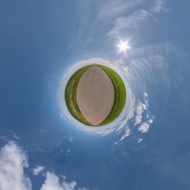 Pequeño planeta verde en el cielo azul con sol y hermosas nubes Transformación del panorama esférico 360 grados Vista aérea abstracta esférica Curvatura del espacio