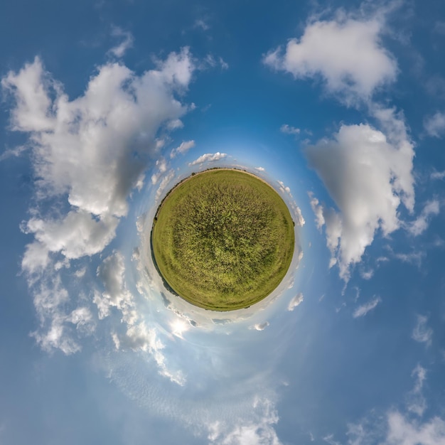 Pequeno planeta verde no céu nublado azul com belas nuvens com transformação do panorama esférico 360 graus Vista aérea abstrata esférica Curvatura do espaço