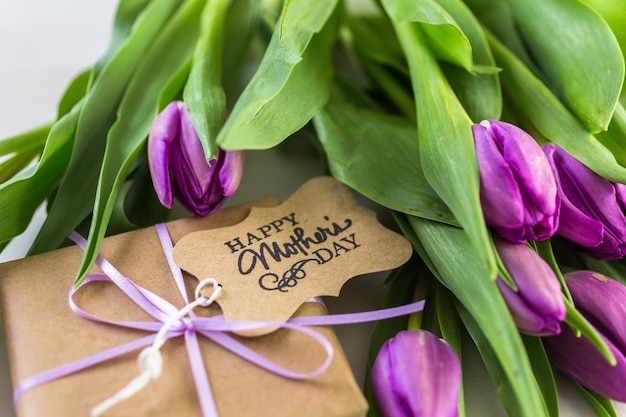 Pequeno presente e tulipas roxas para o dia das mães.