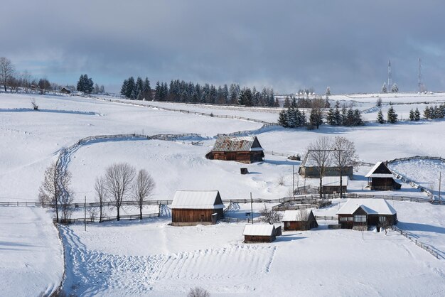 Pequeño pueblo de invierno en las montañas cubierto de nieve