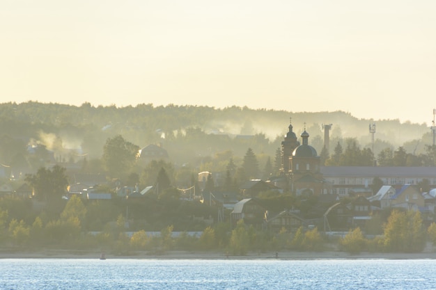 El pequeño pueblo a orillas del río Volga cubierto de niebla en el medio Volga