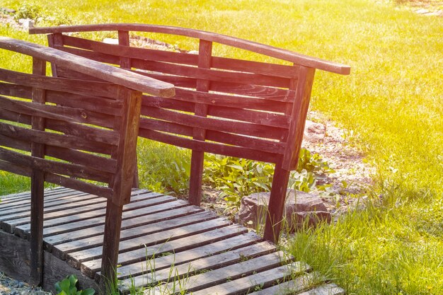 pequeño puente de madera en un hermoso jardín verde.