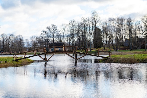 Un pequeño puente de madera desde la orilla hasta una pequeña isla en el lago en el parque señorial