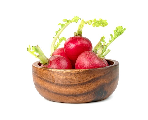 Foto pequeño rábano rojo en un cuenco de madera aislado sobre un fondo blanco