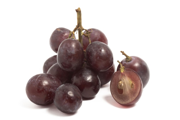 Un pequeño racimo y rodajas de uvas rojas orgánicas frescas deliciosa fruta aislada sobre fondo blanco