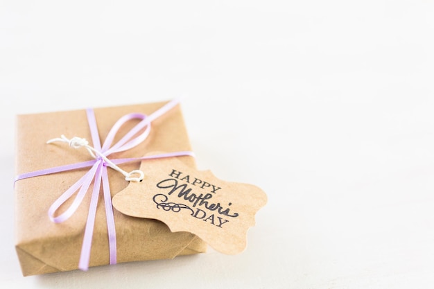 Pequeño regalo para el Día de la Madre en una tabla de madera blanca.