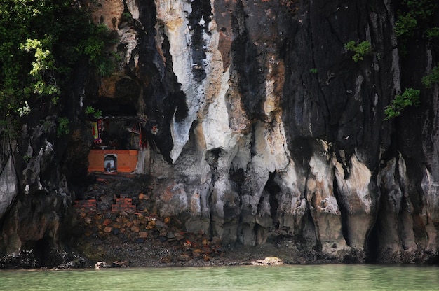 Pequeño santuario en una cueva de piedra caliza para los vietnamitas y los viajeros extranjeros visitan el respeto al dios ángel de la deidad orante en Halong o Ha Long Bay Sitio del Patrimonio Mundial Natural de la UNESCO en Hanoi Vietnam