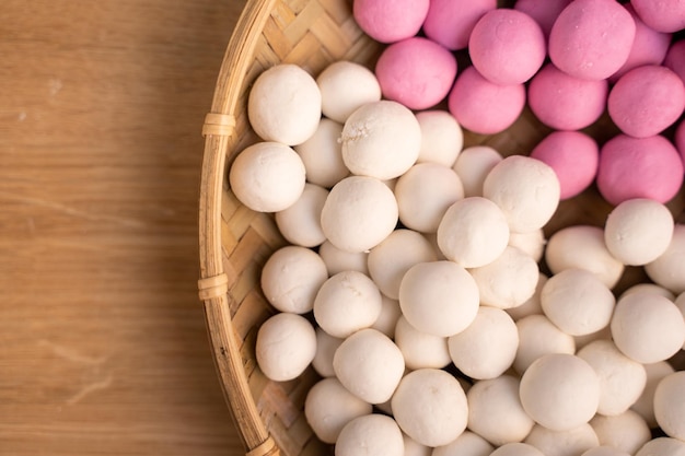 Pequeño tangyuan crudo en un tamiz sobre una mesa de madera