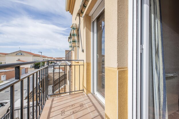 Pequeno terraço de uma casa isolada de dois andares em um dia claro com nuvens