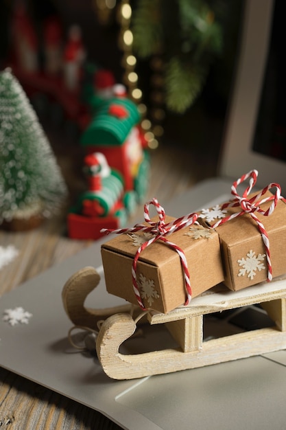 Pequeño trineo de madera con regalos de Navidad en un portátil Closeup