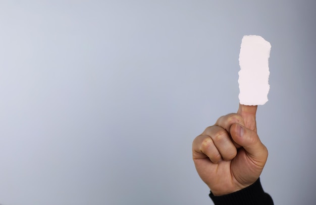 Un pequeño trozo de papel blanco en su mano.