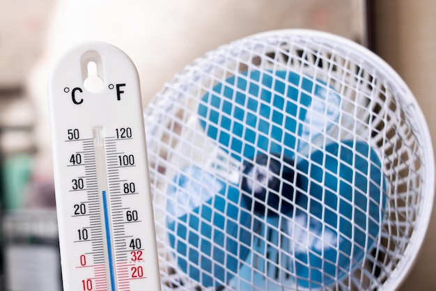 Foto pequeño ventilador y primer plano del termómetro de mercurio de la habitación