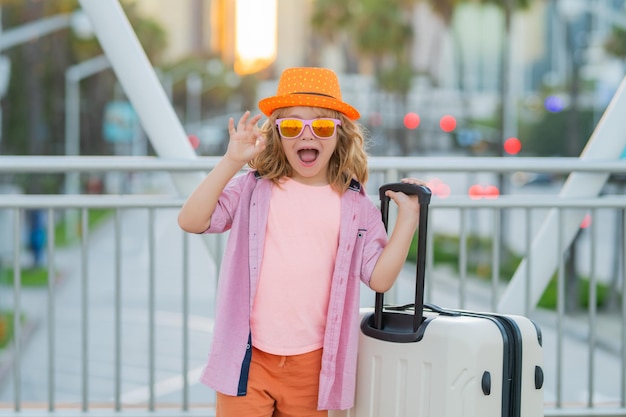 Pequeño viajero con maleta niño feliz turista con bolsa de viaje niño viajero con maleta trave