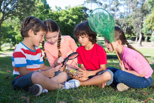 Pequeños amigos felices que miran el tarro