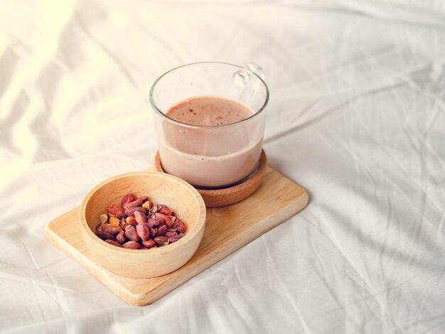 Pequeños aperitivos conjunto de frijoles salados y chocolate caliente servido en la cama.