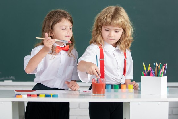 Pequeños artistas pintando niños dibujando arte Retrato niños de la escuela haciendo tareas de arte Niños dibujando en