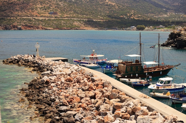 Pequenos barcos de pesca no cais na vila de pescadores chamada Bali com montanhas ao fundo em Creta, Grécia.