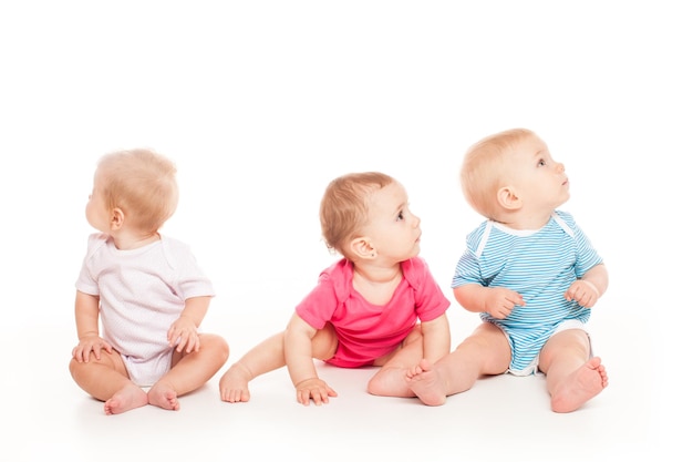 Pequeños bebés están jugando sobre fondo blanco Pequeños amigos en un piso