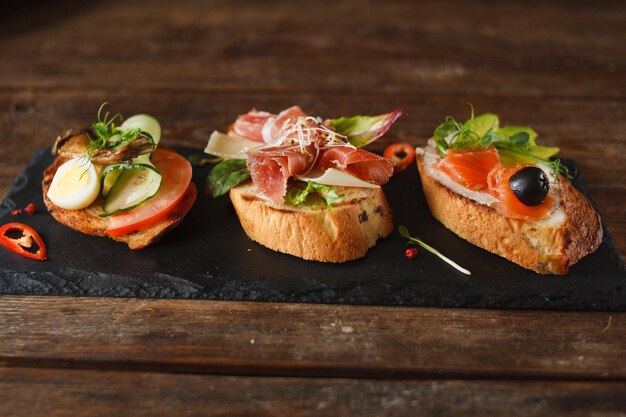 Pequeños canapés en bandeja negra