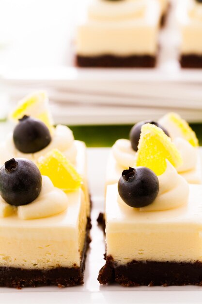 Pequeños cuadrados de tarta de queso de chocolate blanco en la barra de postres.