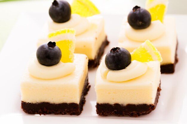 Pequeños cuadrados de tarta de queso de chocolate blanco en la barra de postres.