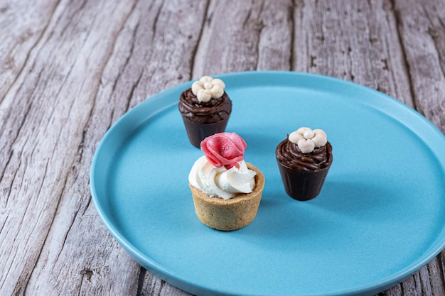 Pequenos doces sofisticados recheados com ganache de chocolate e cobertos com chantilly e cobertura de fondant