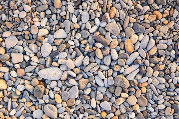 Pequeños guijarros coloridos o piedra en la playa de guijarros marinos como fondo